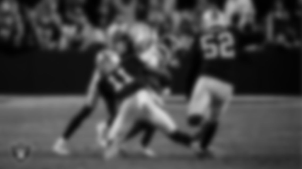 Las Vegas Raiders cornerback Darien Porter (26) and safety Jeremy Chinn (11) make a tackle during the regular season home game against the Denver Broncos at Allegiant Stadium.