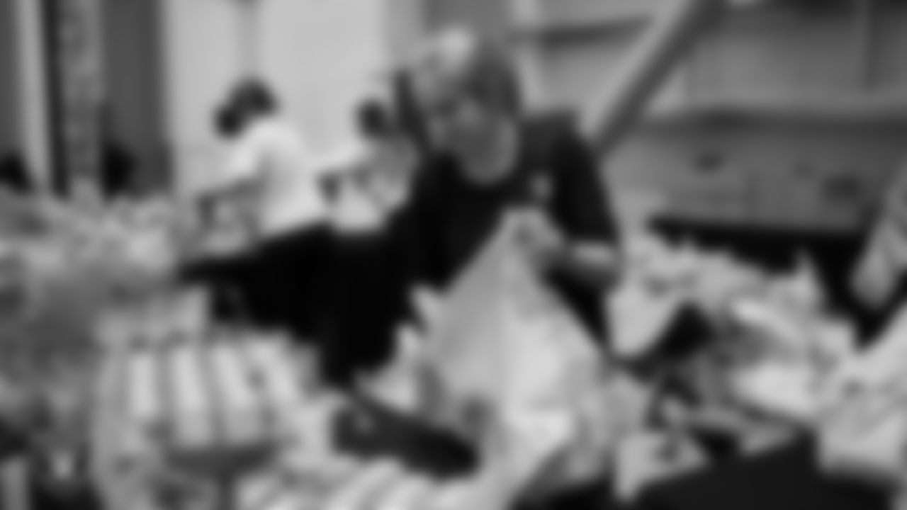 Las Vegas Raiders staff members help pack meals during the Raiders Holiday Meal Packing Party at Intermountain Health Performance Center.