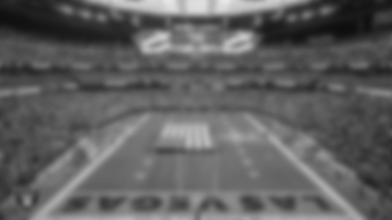 The American flag is displayed by Personal Seat License (PSL) holders on the field during the national anthem before the Las Vegas Raiders' regular season home game against the Denver Broncos at Allegiant Stadium.