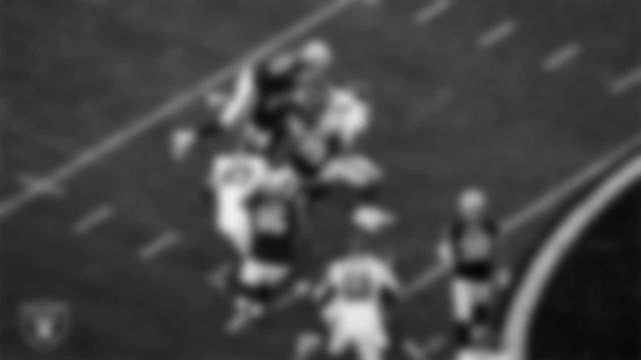 Las Vegas Raiders defensive lineman Jerry Tillery (90), linebacker Robert Spillane (41) and cornerback Nate Hobbs (39) make a tackle during the regular season home game against the New York Giants at Allegiant Stadium.