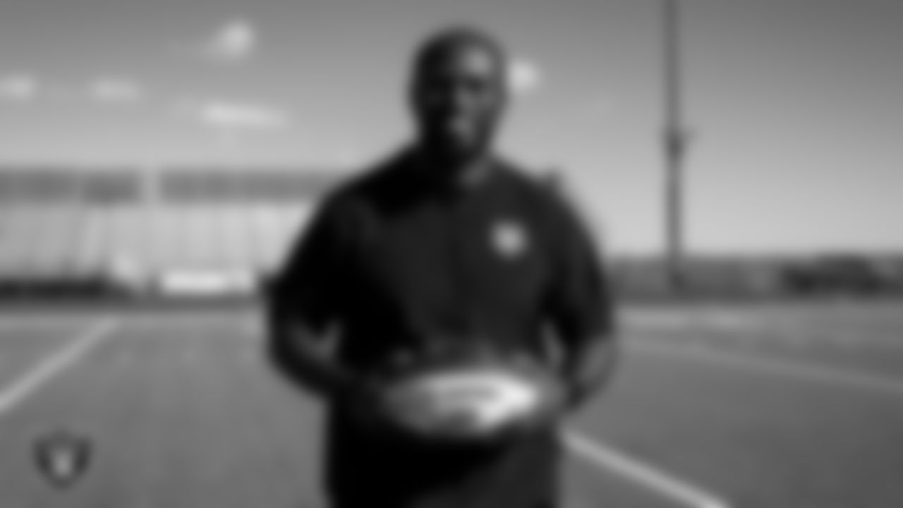 Centennial High School football coach DJ Campbell poses for a photo with the Tom Flores High School Coach of the Week custom football during practice at Centennial High School.