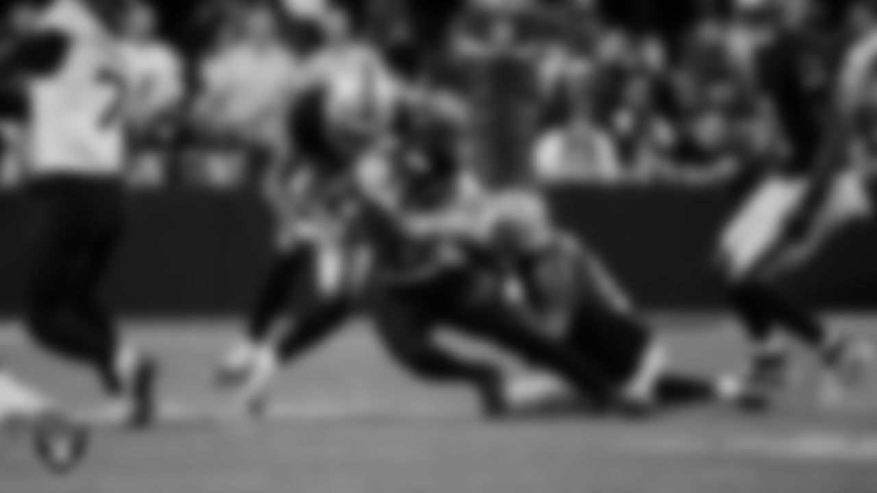 Las Vegas Raiders safety Isaiah Pola-Mao (20) and defensive end Malcolm Koonce (51) make a tackle during the regular season home game against the Jacksonville Jaguars at Allegiant Stadium.