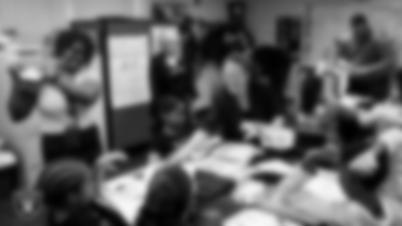 Las Vegas Raiders director of marketing communications Nell Warkoski hands out Raiders gear to students during a Lil' Raiders Pop-Up at Matt Kelly Elementary School.