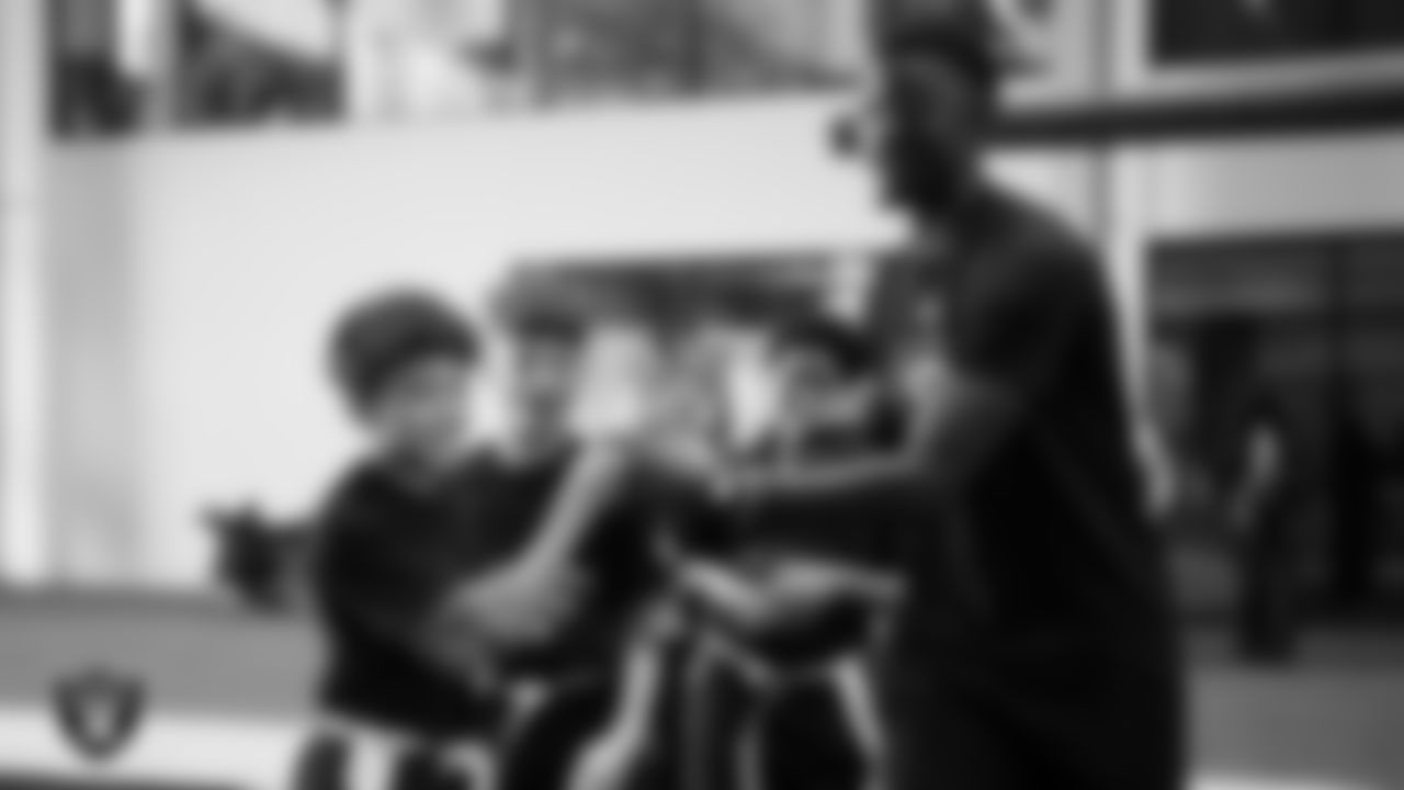 A member of the Grambling State University football team fist bumps students during a Raiders Junior Training Camp at Intermountain Health Performance Center.
