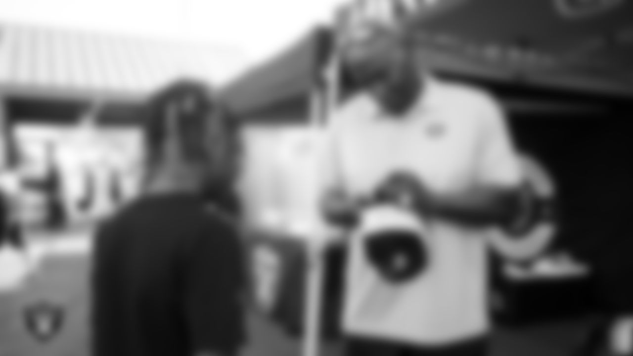 Las Vegas Raiders alumnus Reggie Kinlaw signs an autograph before the Raiders' Football Showcase game at Canyon Springs High School.