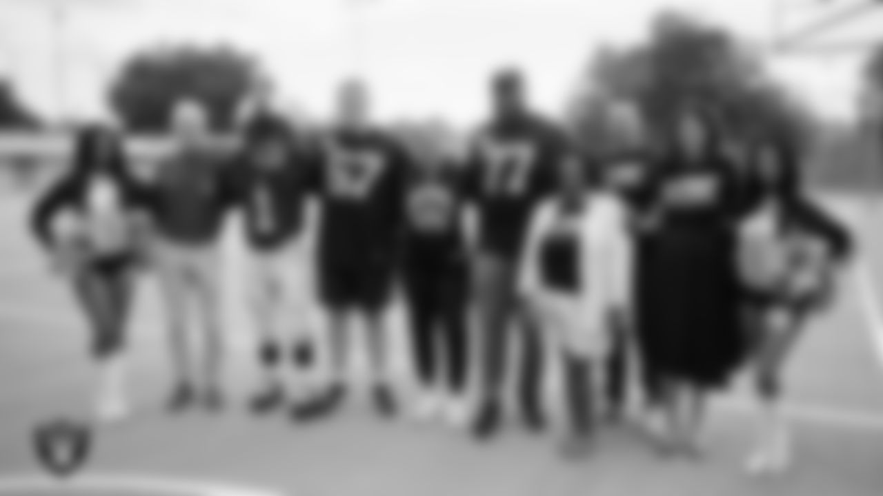 Raiderettes Cierra and Kylee and Las Vegas Raiders center Will Putnam (67) and tackle Thayer Munford Jr. (77) pose for a photo with teachers while celebrating Teacher Appreciation Week at Matt Kelly Elementary School.