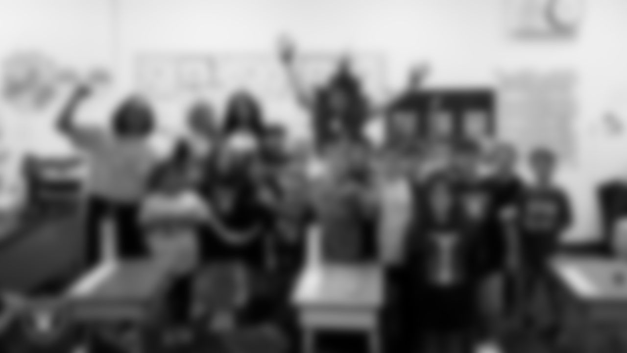 Raiderettes Pip and Sloane and Raider Rusher pose for a photo with a class during a 'Lil Raiders Pop-Up at Richard H. Bryan Elementary School.