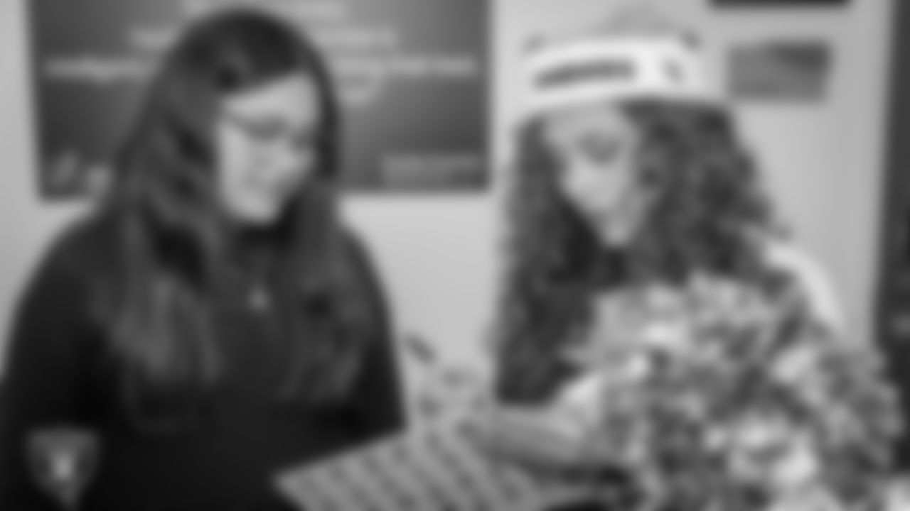 Raiderette Lexie signs an autograph during a toy drive at Intermountain Health Primary Children's Hospital.