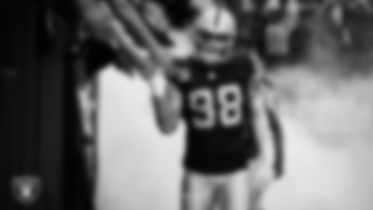 Las Vegas Raiders defensive end Maxx Crosby (98) high-fives fans before being introduced onto the field before the regular season home game against the Tennessee Titans at Allegiant Stadium.