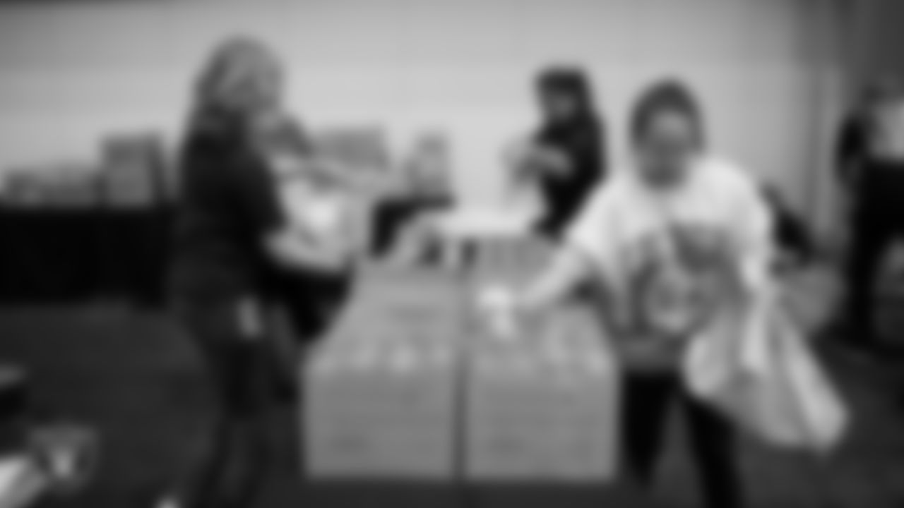 Las Vegas Raiders staff members help pack meals during the Raiders Holiday Meal Packing Party at Intermountain Health Performance Center.