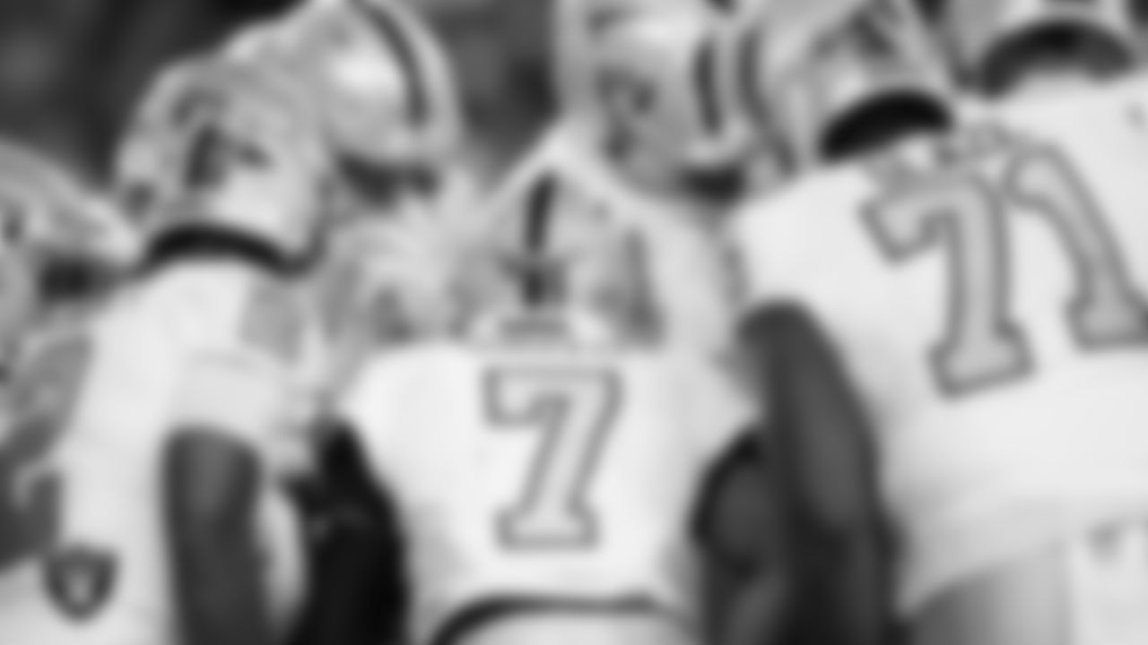 The Las Vegas Raiders huddle during the regular season away game against the Denver Broncos at Empower Field at Mile High.