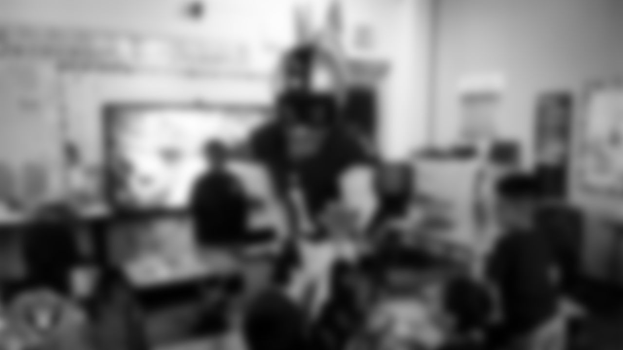 Raider Rusher gives a high-five to a student during a 'Lil Raiders Pop-Up at Richard H. Bryan Elementary School.