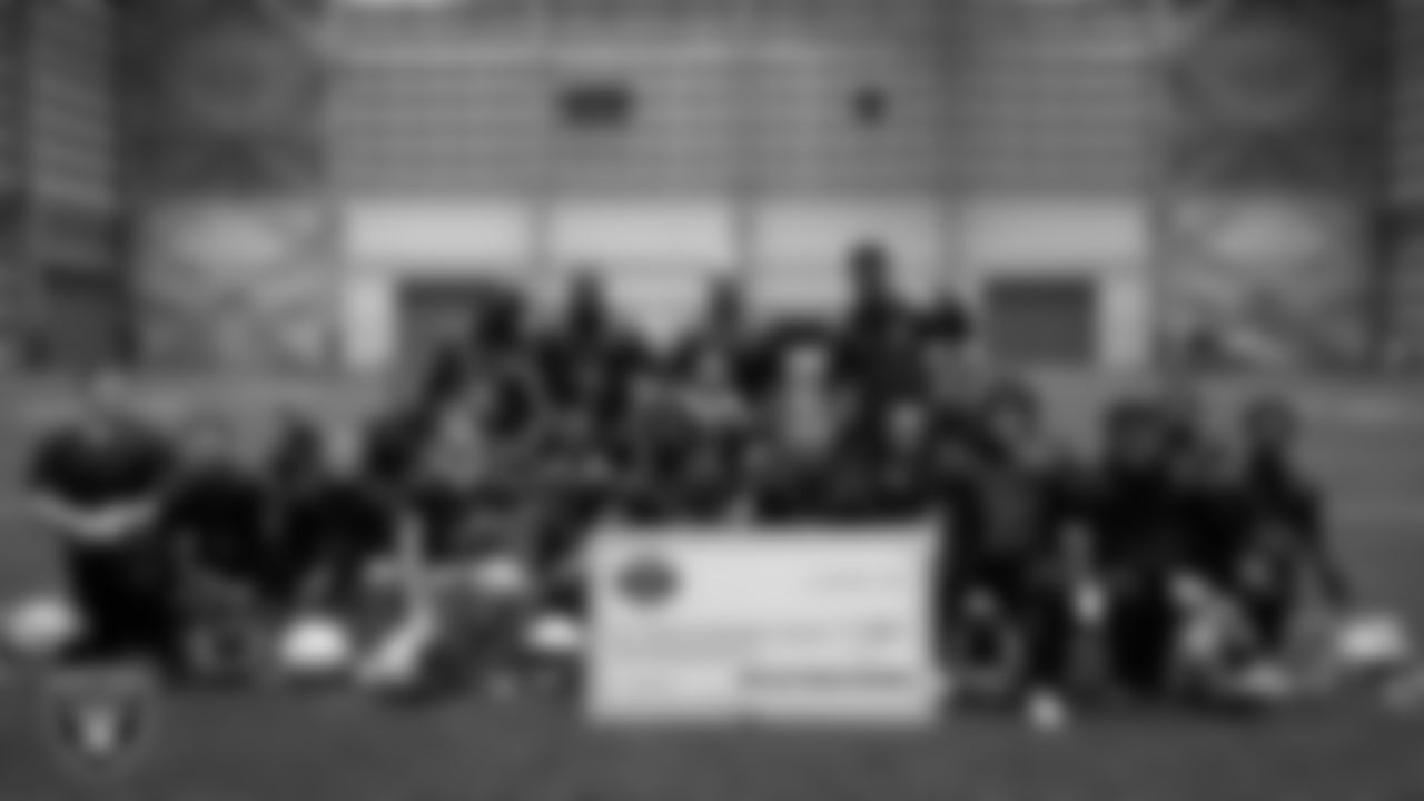 Athletes pose for a photo after receiving a check to go towards their travels for nationals during an open practice at Intermountain Health Performance Center.