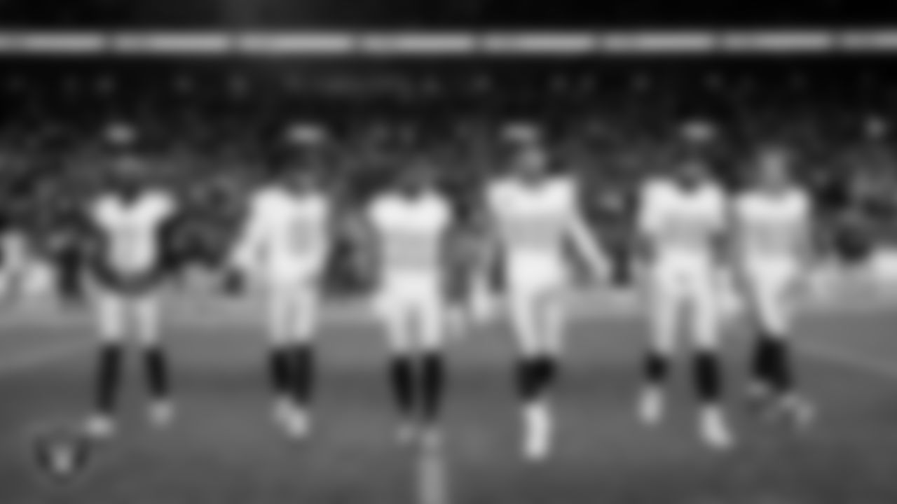 The Las Vegas Raiders walk out to the center of the field for the coin toss before the regular season away game against the the Denver Broncos at Empower Field at Mile High.
