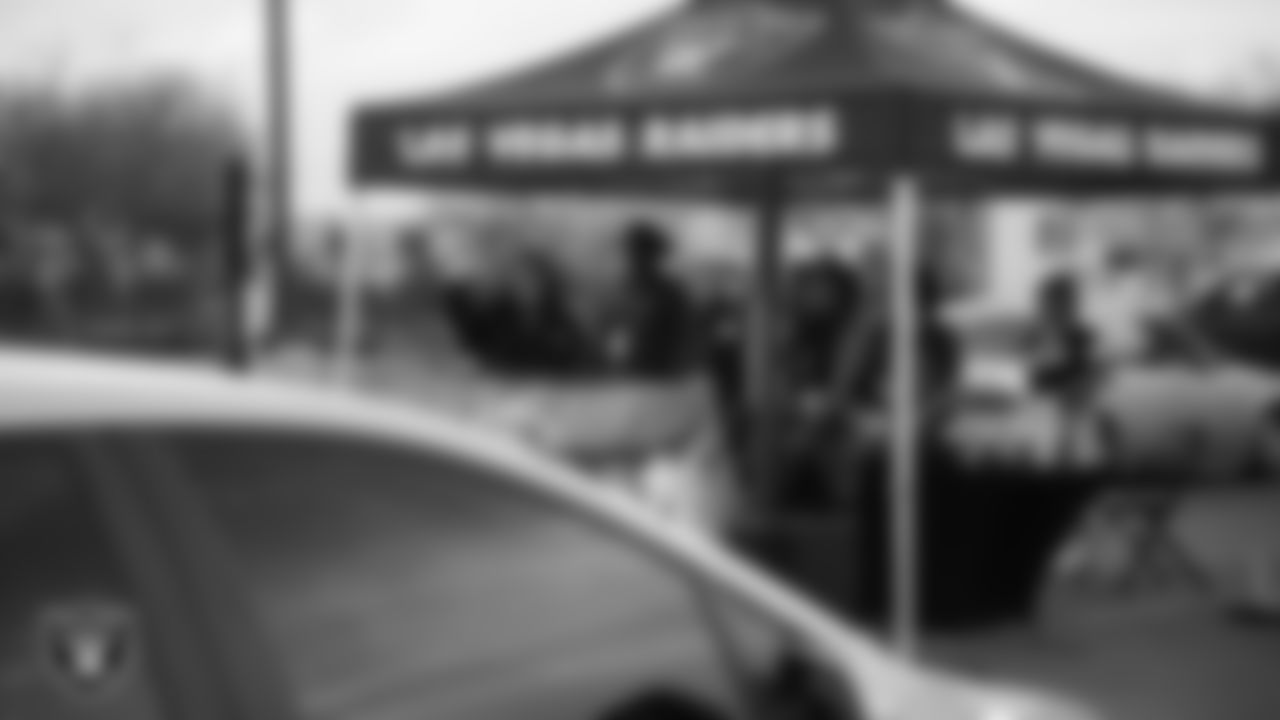 Members of radio station Power 88 KCEP-FM wave to attendees during Turkey Time with the O-Line at Allegiant Stadium.