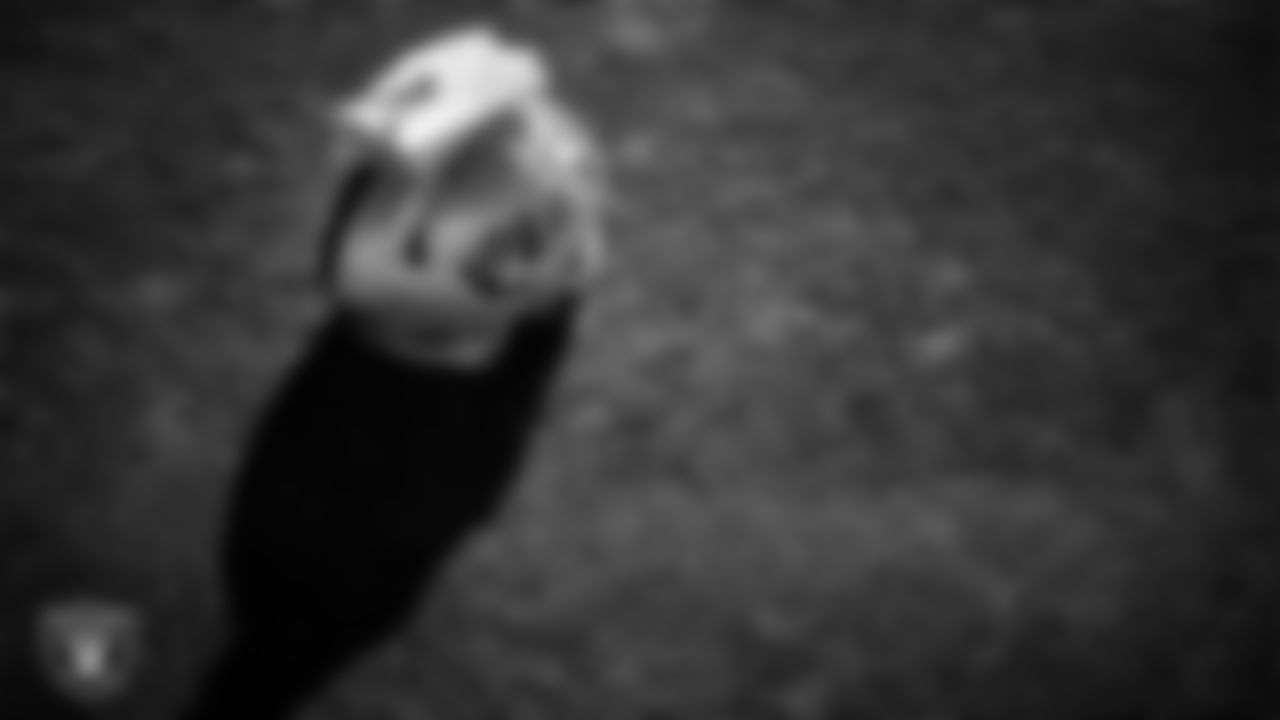 A Las Vegas Raiders' helmet and gloves on the field during practice at Intermountain Health Performance Center.