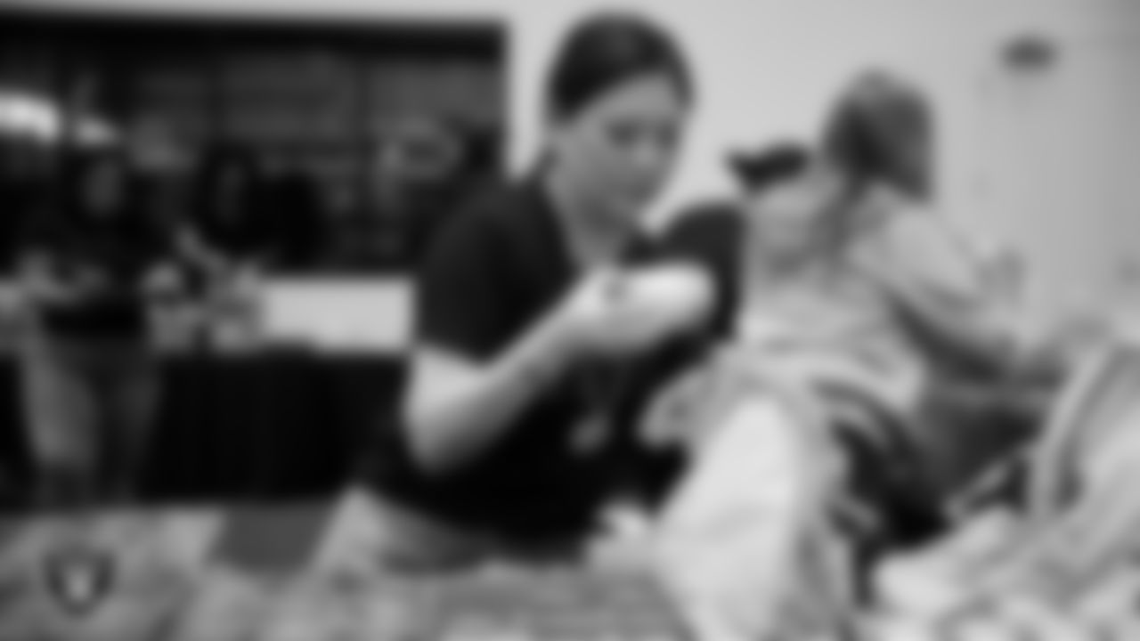 Las Vegas Raiders staff members help pack meals during the Raiders Holiday Meal Packing Party at Intermountain Health Performance Center.