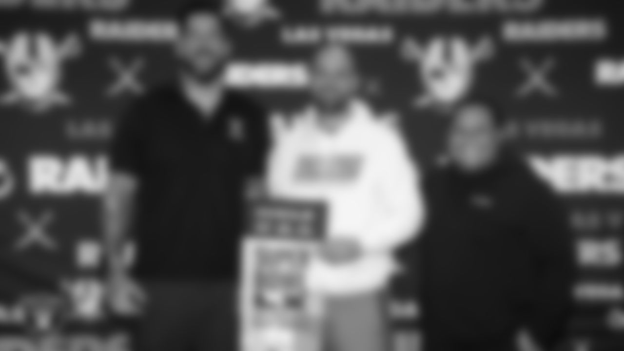 Las Vegas Raiders alumnus Robert Gallery and senior manager of football development Jordan Aguilar pose for a photo with Spanish Springs High School football coach and Tom Flores High School Coach of the Year Rob Hummel after surprising him with Super Bowl LX tickets during a Glazier Clinic at Grand Sierra Resort.