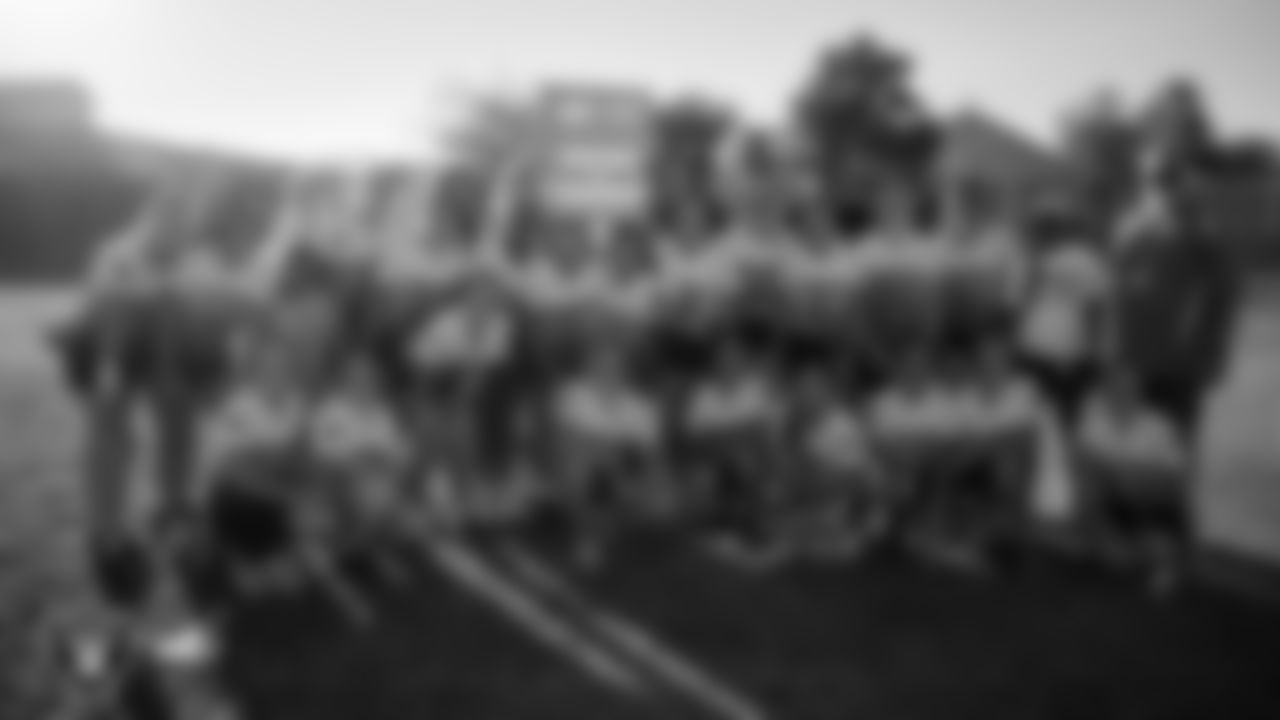 Las Vegas Raiders alumnus Leo Gray poses for a photo with the Charles Hughes Middle School flag football team after the Las Vegas Raiders' Middle School Flag Football Showcase game at Ralph Cadwallader Middle School.