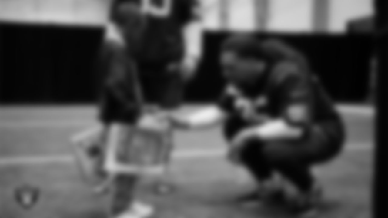 Las Vegas Raiders defensive tackle Leki Fotu (95) helps a student select toys during a Raiders Youth Holiday Party at Intermountain Health Performance Center.