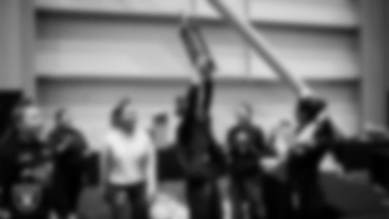 Members of the winning team of the Raiders Holiday Meal Packing Party competition celebrate at Intermountain Health Performance Center.