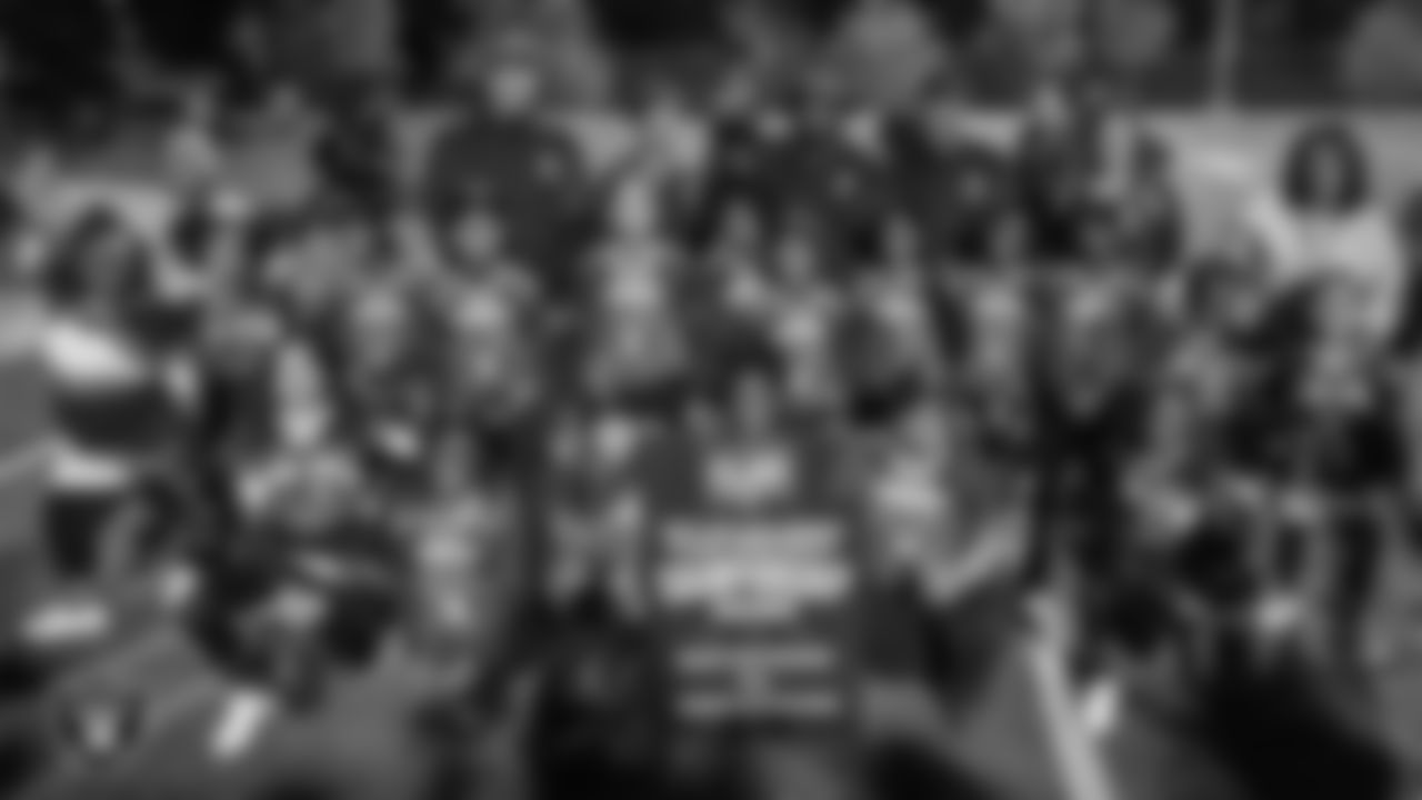 Athletes, coaches and cheerleaders pose for a photo after the City of Las Vegas Silver and Black Youth Flag Football League championship game at All American Park.