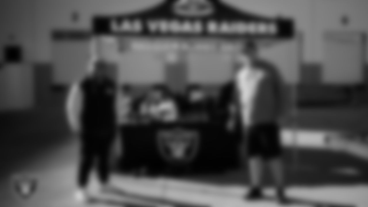 Las Vegas Raiders senior manager of football development Jordan Aguilar poses for a photo with a coach during the Raiders' Equipment Blitz at Intermountain Health Performance Center.
