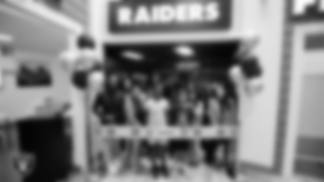 Las Vegas Raiders staff members and students pose for a photo during a ribbon cutting at Betty's Junior Achievement BizTown.