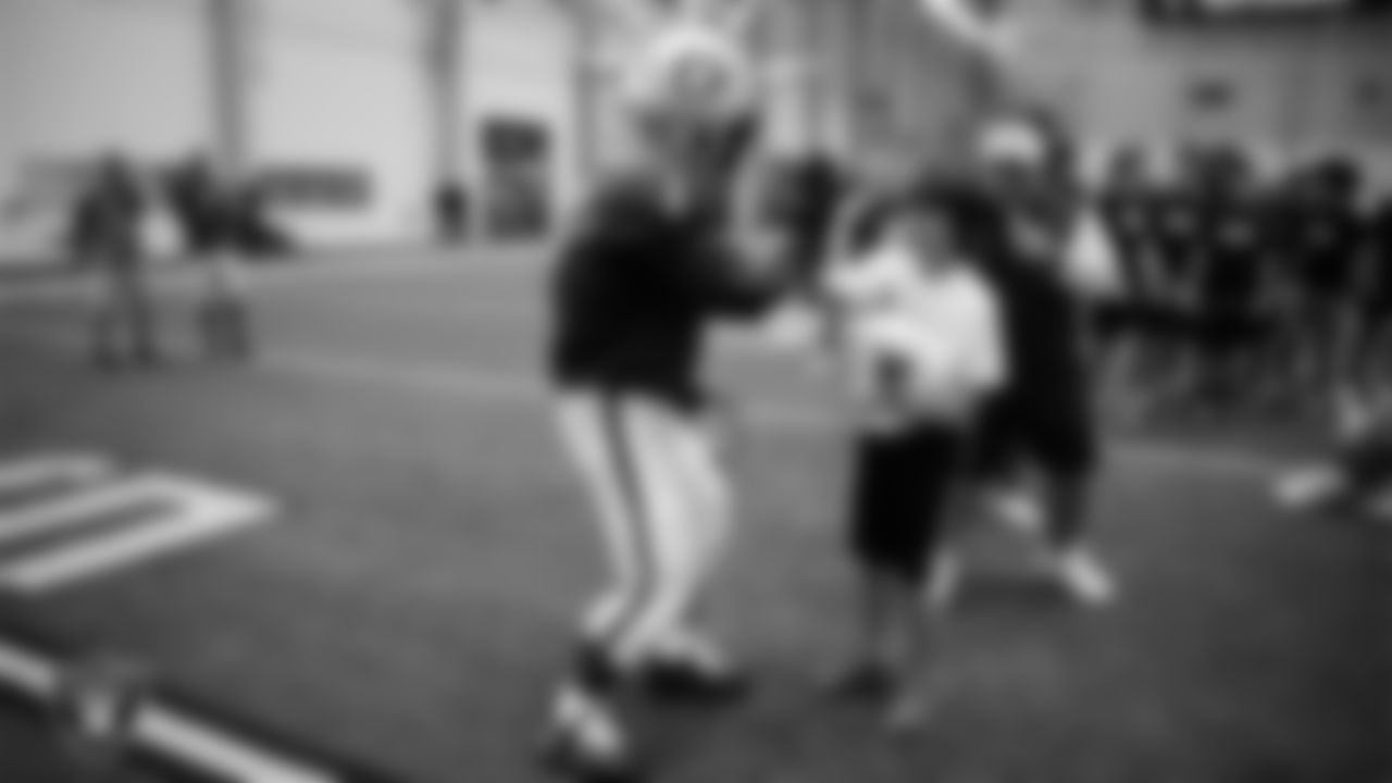 Raider Rusher high fives an athlete at a skills camp during Play Football Day at Intermountain Health Performance Center.