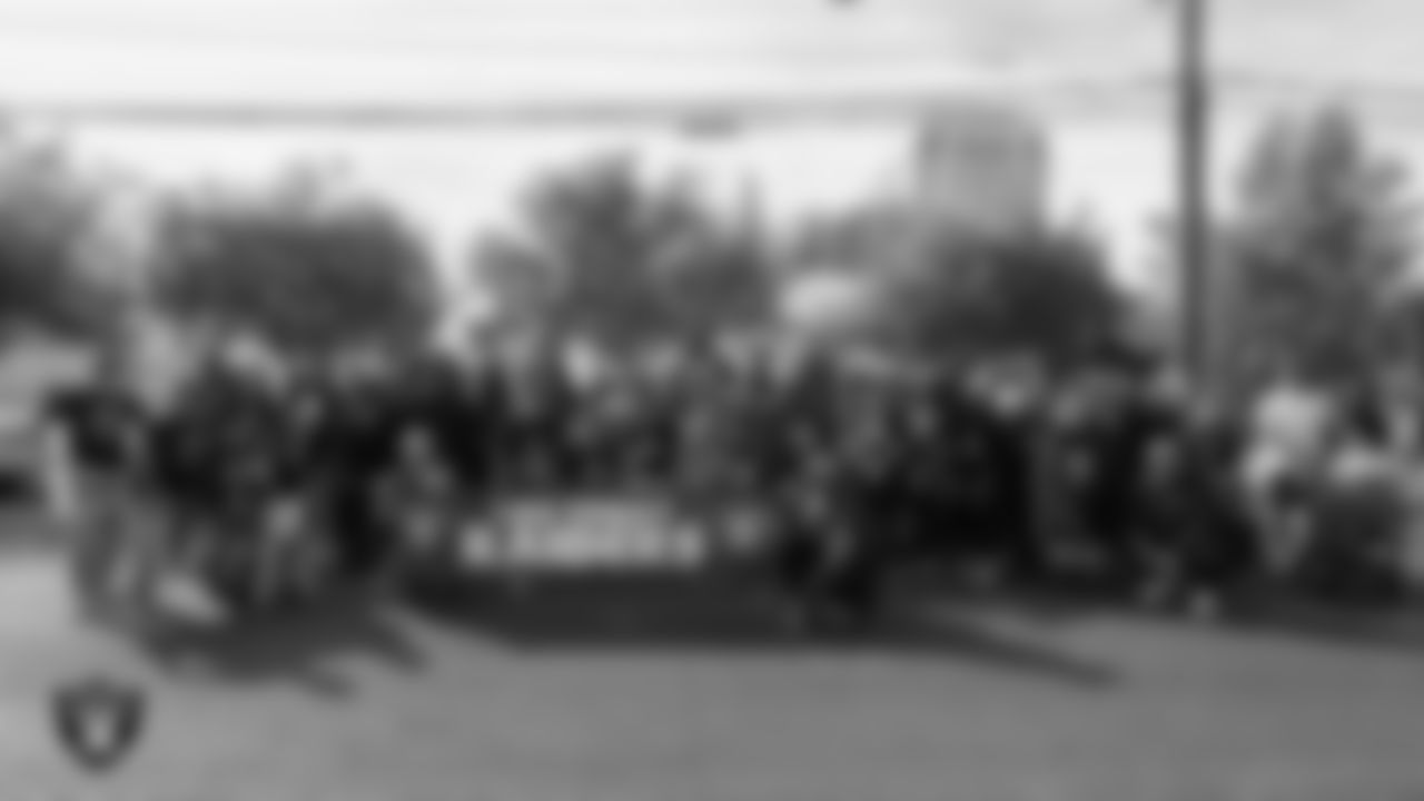 The Las Vegas Raiders and members of U.S. VETS - Las Vegas pose for a photo during the Veterans Day Parade in Downtown Las Vegas.