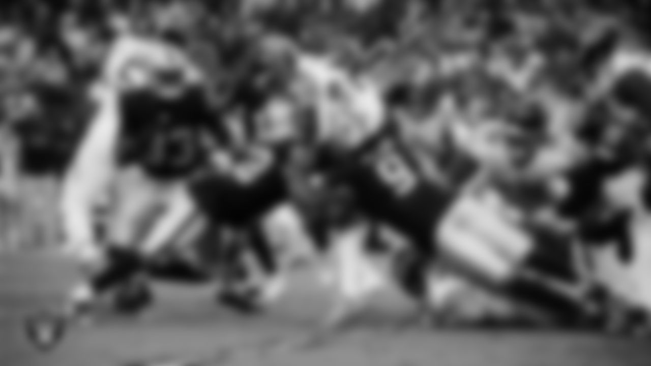 Las Vegas Raiders linebacker Elandon Roberts (52) and defensive end Tyree Wilson (9) make a tackle during the regular season home game against the Tennessee Titans at Allegiant Stadium.