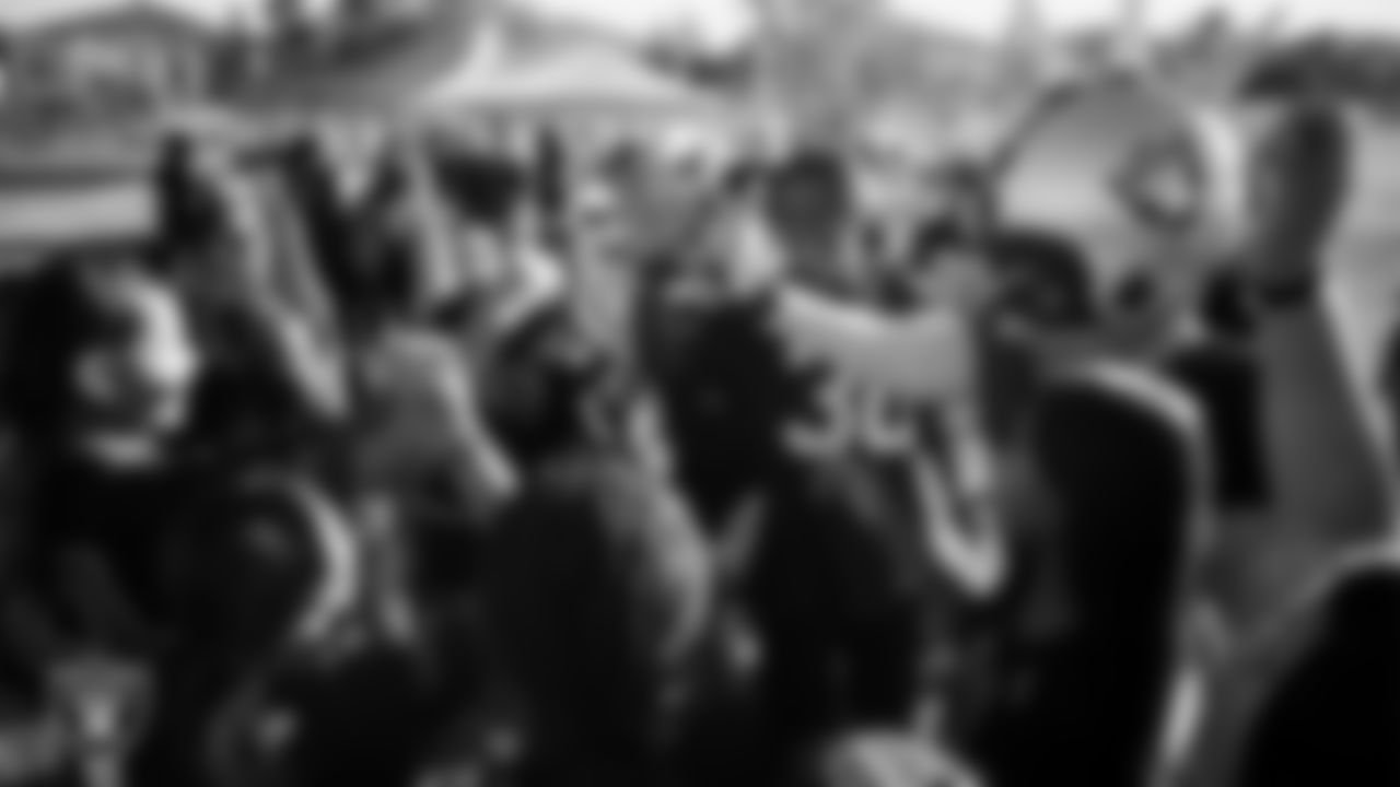 Las Vegas Raiders cornerback Darnay Holmes (30) and Raider Rusher huddle with the Charles Silvestri Junior High School girls flag football team after the Raiders' Middle School Flag Football Showcase game at Charles Silvestri Junior High School.