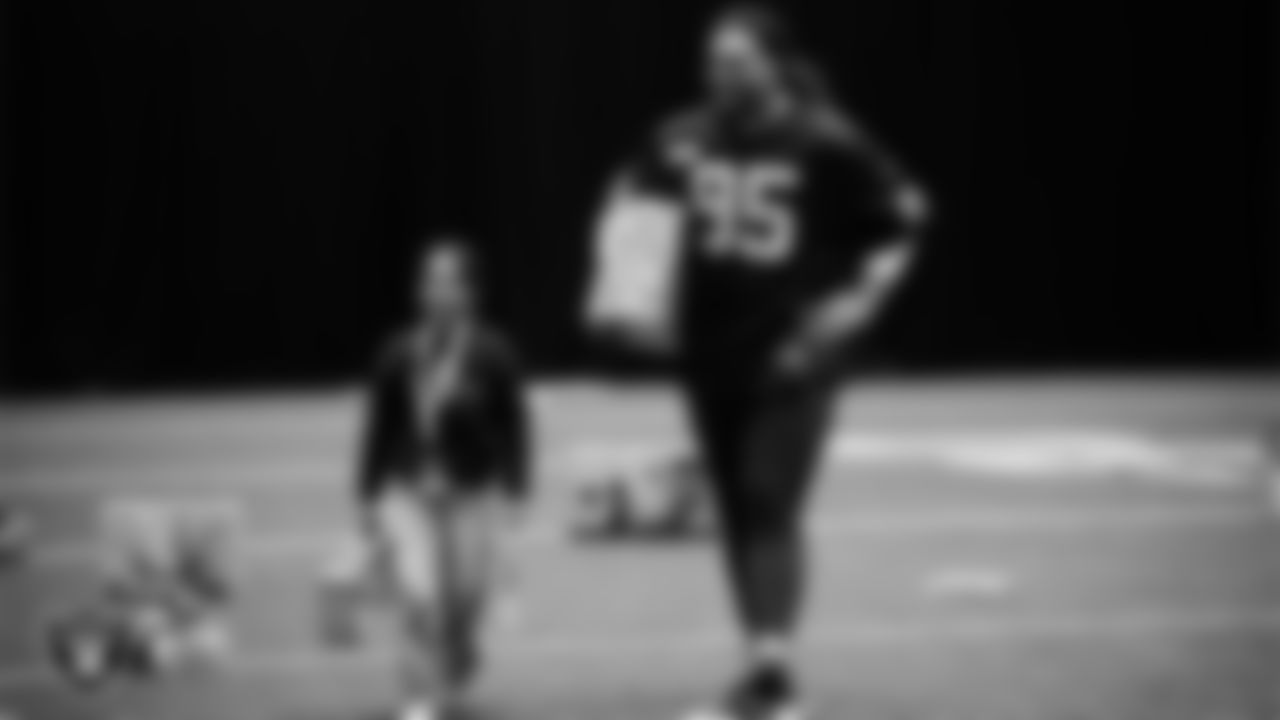 Las Vegas Raiders defensive tackle Leki Fotu (95) helps a student select toys during a Raiders Youth Holiday Party at Intermountain Health Performance Center.