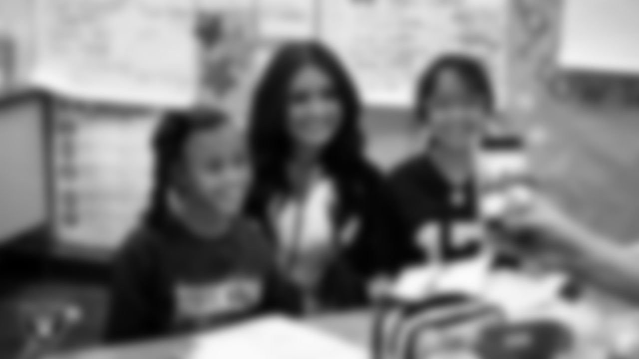 Raiderette Sloane poses for a photo with students during a 'Lil Raiders Pop-Up at Richard H. Bryan Elementary School.