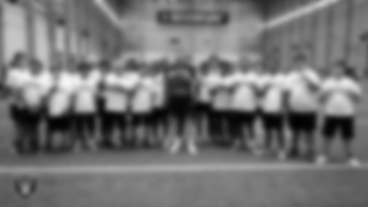 Las Vegas Raiders defensive end Maxx Crosby (98) poses for a photo with the Western High School football team during the Raiders Play Football Skills Camp at Intermountain Health Performance Center.