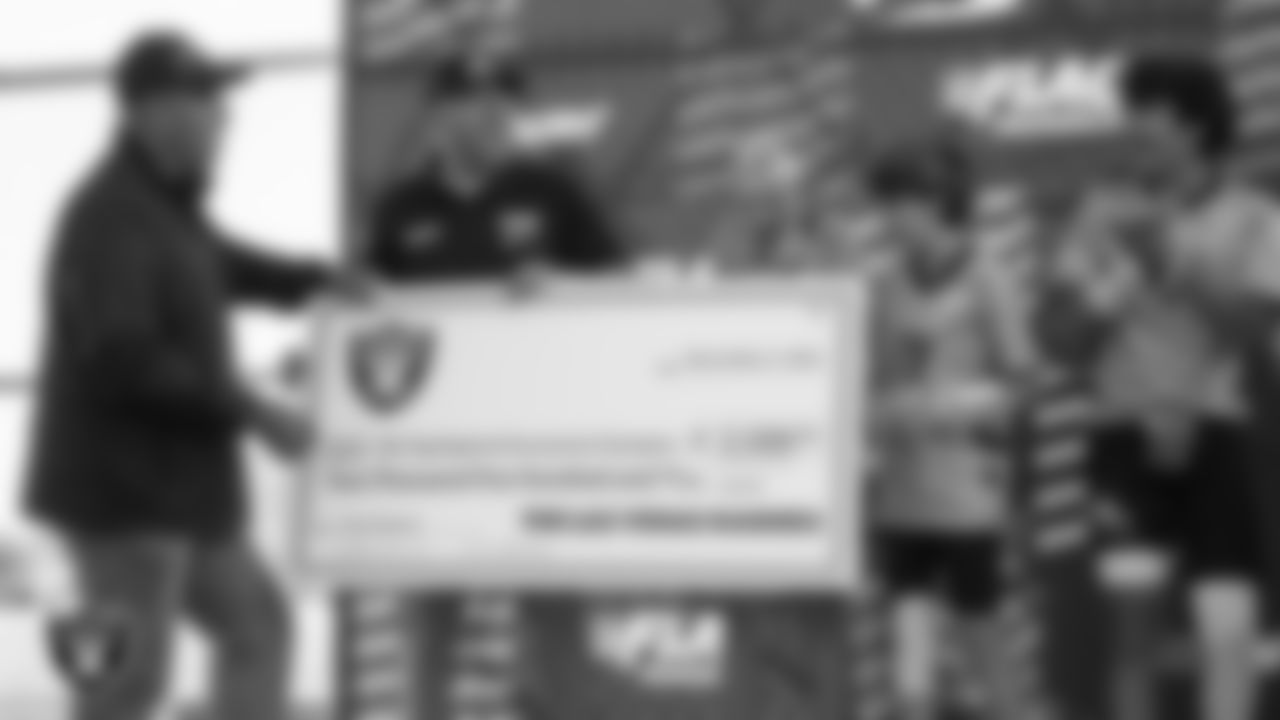 Las Vegas Raiders alumnus Chris McLemore presents a check to the 12U Dethrone FC after they won the 2024 NFL FLAG Regional Championships and advanced to the 2024 NFL FLAG Championship at Heritage Park.