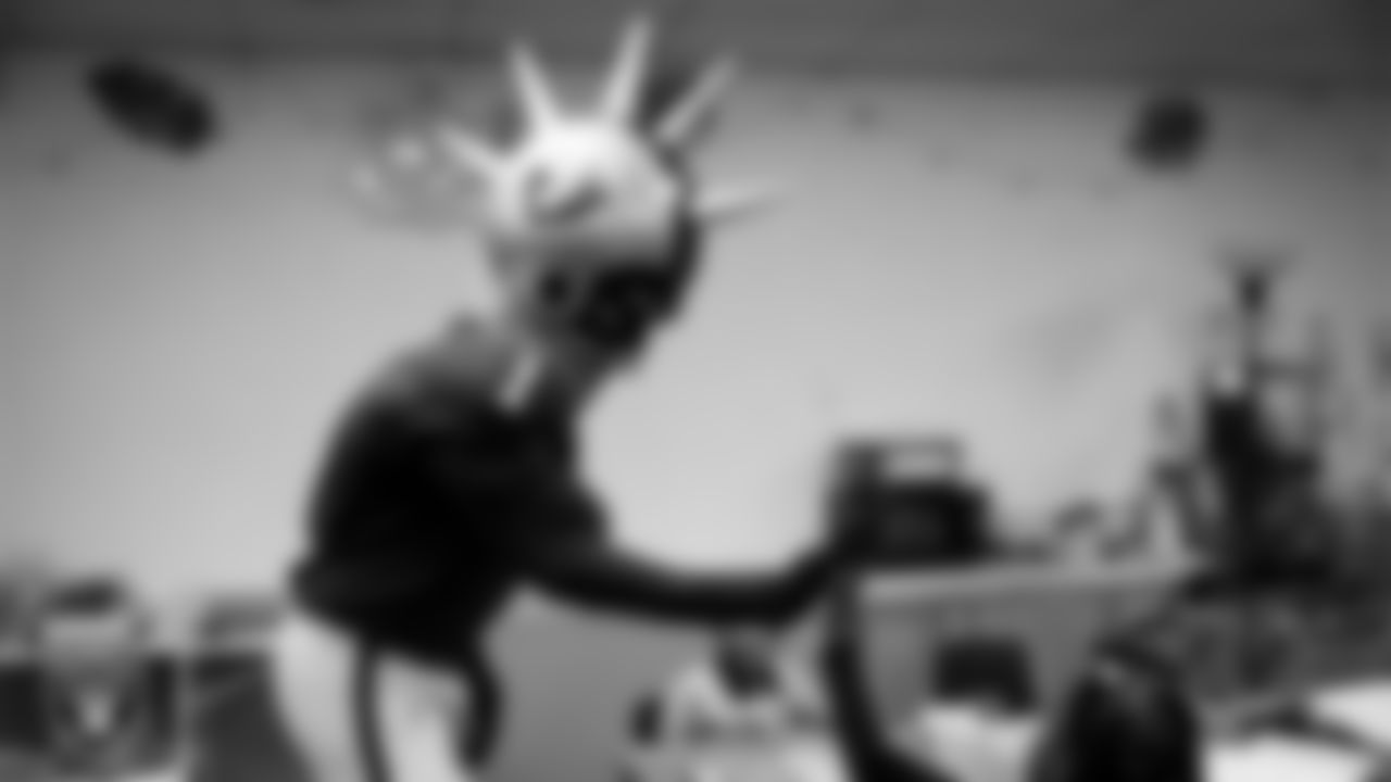 Raider Rusher gives a high-five to a student during a 'Lil Raiders Pop-Up at Matt Kelly Elementary School.