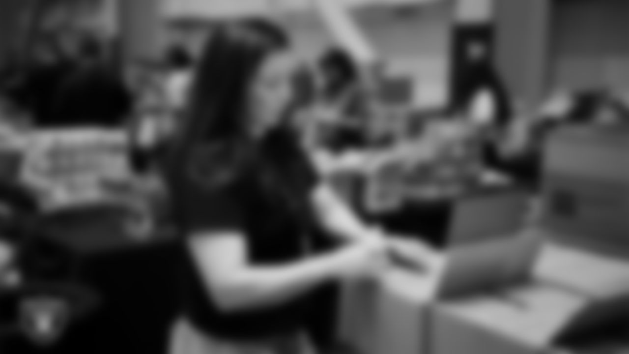 Las Vegas Raiders staff members help pack meals during the Raiders Holiday Meal Packing Party at Intermountain Health Performance Center.