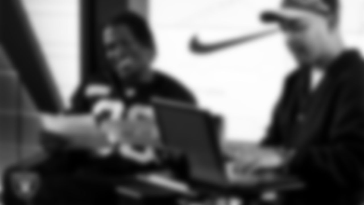 Las Vegas Raiders cornerback Darnay Holmes (30) works with representatives from Merging Vets and Players and designers to design cleats for My Cause My Cleats in Cox Studios at Intermountain Health Performance Center.