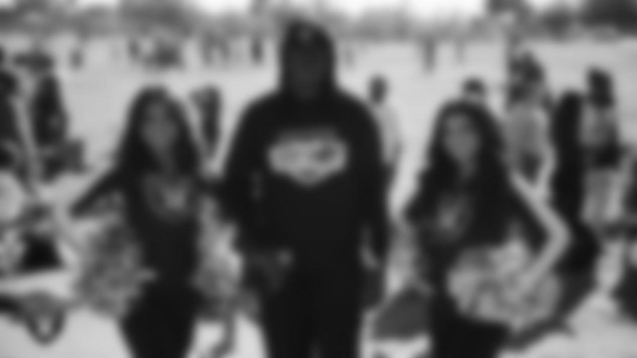 Raiderettes Kylee and Sloane pose for a photo with Robert Strawder of Hip Hop & Entrepreneurship during the LEEAP Flag Football Tournament at Desert Breeze Park.