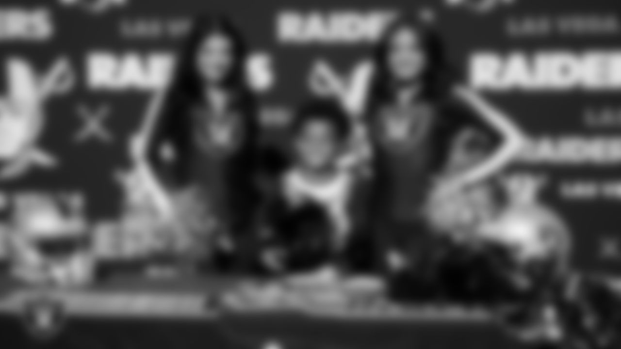 Raiderettes Kylee and Sloane pose for a photo with an athlete during the LEEAP Flag Football Tournament at Desert Breeze Park.