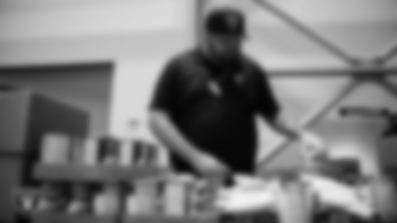 Las Vegas Raiders staff members help pack meals during the Raiders Holiday Meal Packing Party at Intermountain Health Performance Center.