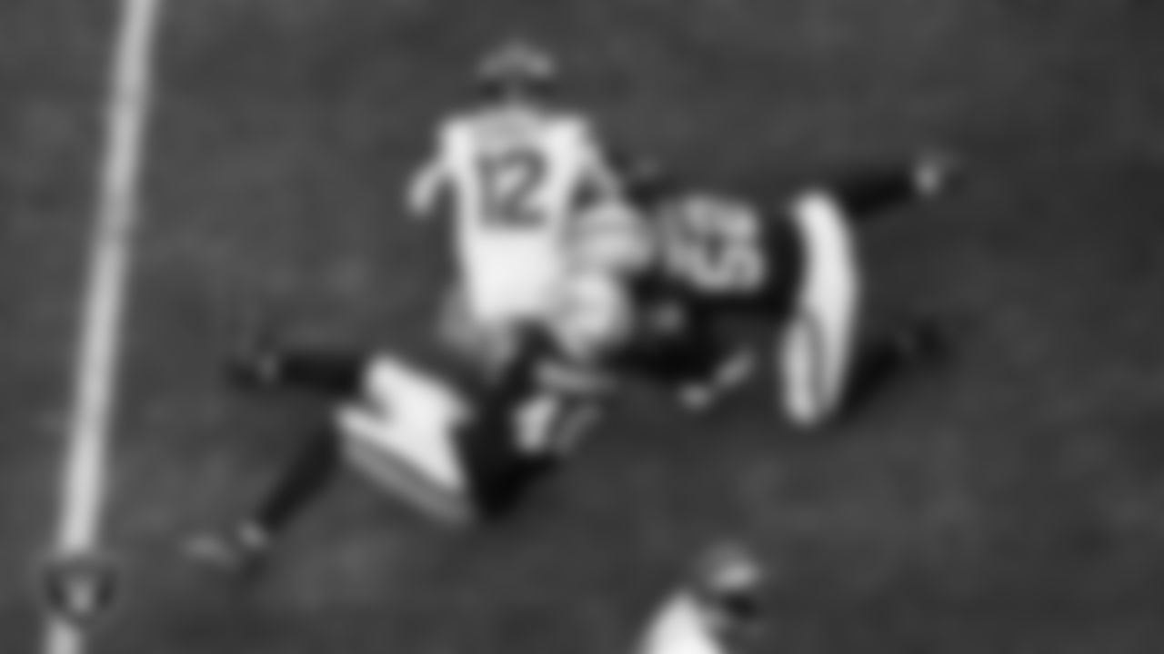 Las Vegas Raiders defensive end Charles Snowden (49) and linebacker Elandon Roberts (52) make a tackle during the regular season home game against the Denver Broncos at Allegiant Stadium.