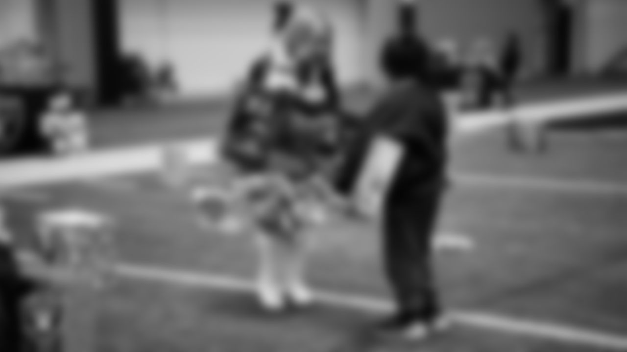 Raiderette Ali helps a student select toys during a Raiders Youth Holiday Party at Intermountain Health Performance Center.