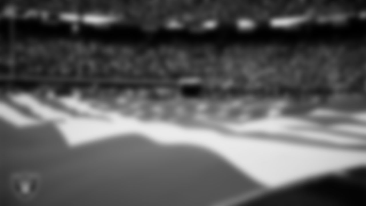 The American flag is displayed by Personal Seat License (PSL) holders on the field during the national anthem before the Las Vegas Raiders' regular season home game against the Kansas City Chiefs at Allegiant Stadium.