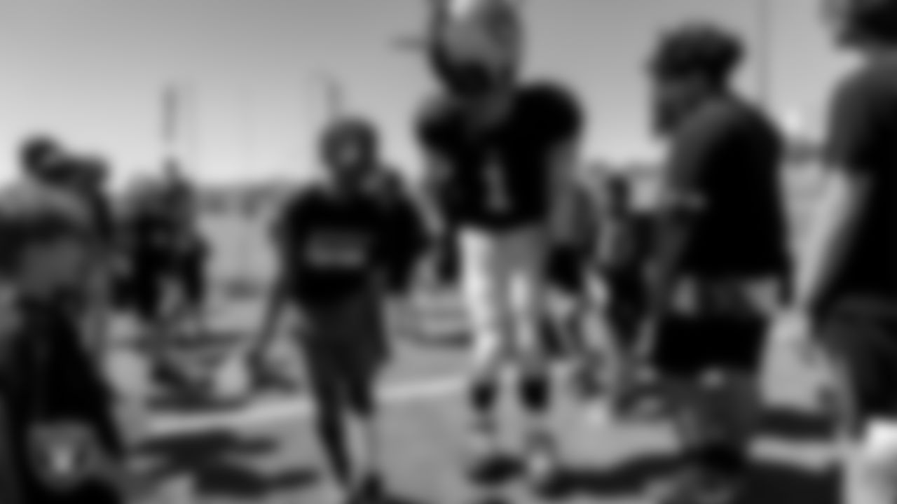 Raider Rusher and an athlete during the Play Football Youth Combine at Silverado High School.