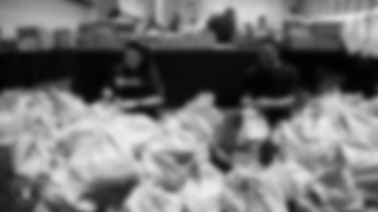 Las Vegas Raiders staff members help pack meals during the Raiders Holiday Meal Packing Party at Intermountain Health Performance Center.