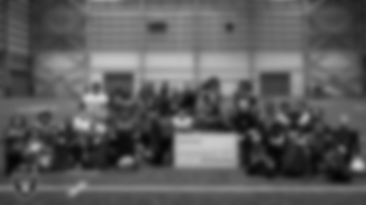 Las Vegas Raiders linebacker Tommy Eichenberg (44) and wide receiver Phillip Dorsett II (13) pose for a photo with athletes after presenting them with a check to go towards travels for nationals during an open practice at Intermountain Health Performance Center.