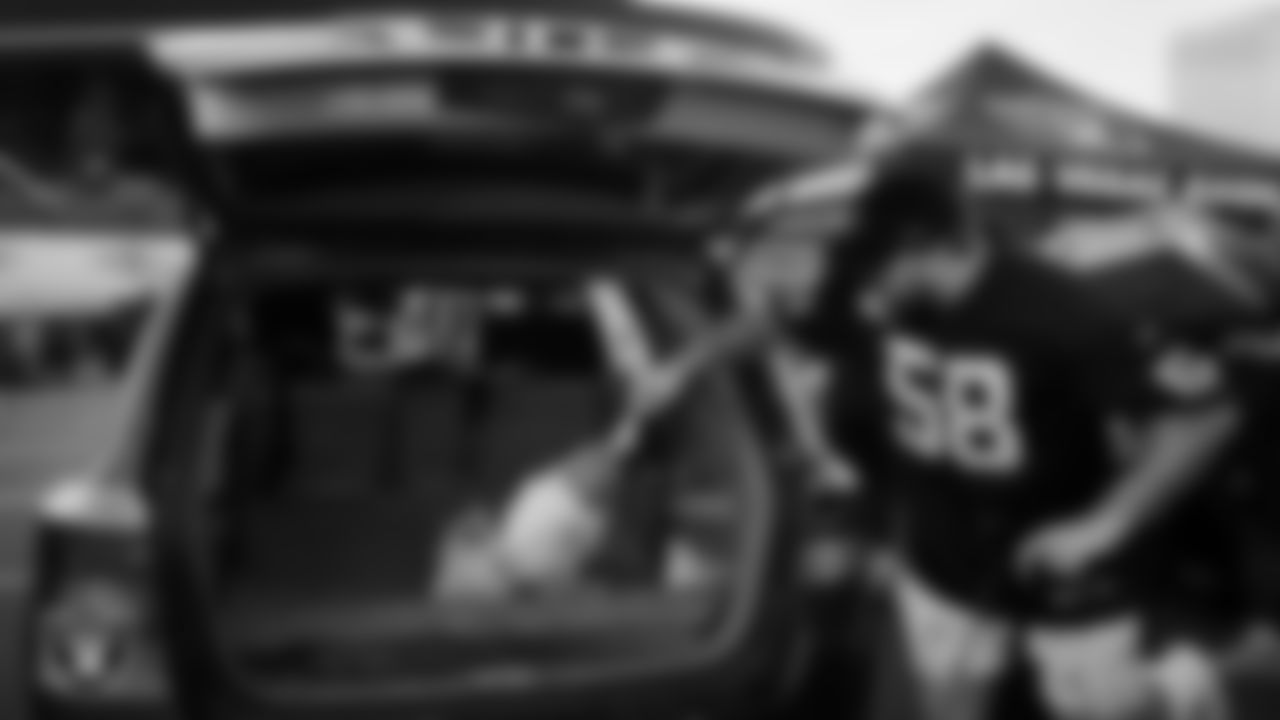 Las Vegas Raiders guard/center Jackson Powers-Johnson (58) helps distribute Thanksgiving meals to families during Turkey Time with the O-Line at Allegiant Stadium.