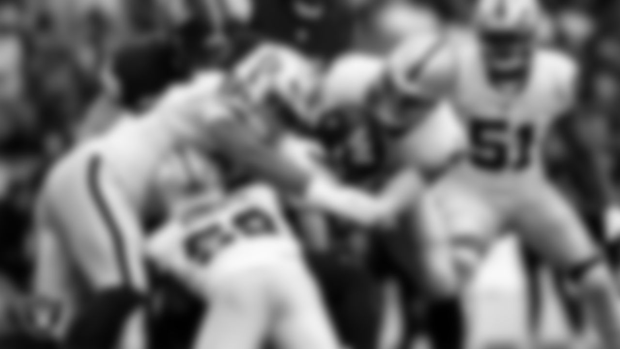 Las Vegas Raiders defensive tackle Jonah Laulu (96), linebacker Elandon Roberts (52) and defensive end Maxx Crosby (98) make a tackle during the regular season away game against the Washington Commanders at Northwest Stadium.